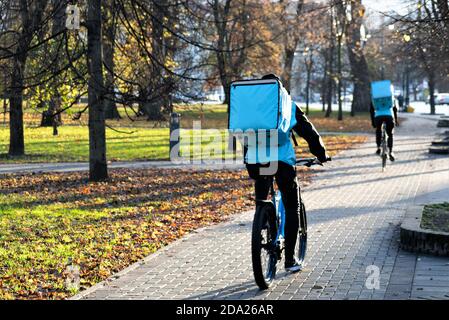 Fahrer mit Fahrrad liefern Lebensmittel, Online-Bestellung von Lebensmitteln und Lieferservice, die Bestellungen über eine mobile App während Covid oder Coronavirus Zeit nimmt Stockfoto