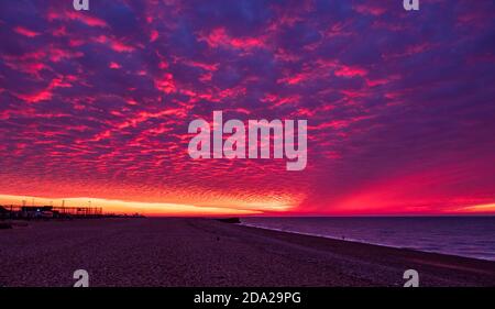 Dramatische November rote Morgendämmerung und Makrelen Wolken Himmel über Hastings Strandfront in Ost-Sussex Süd-Ost-England Stockfoto