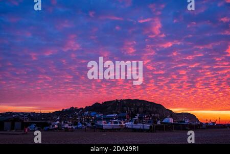 Dramatische November rote Morgendämmerung und Makrelen Wolken Himmel über Hastings Strandfront in Ost-Sussex Süd-Ost-England Stockfoto