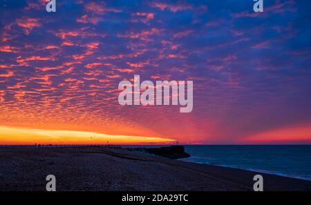 Dramatische rote Morgendämmerung Makrelen Himmel über dem Strand von Hastings In Ost-Sussex Süd-Ost-England Stockfoto