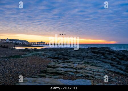 Dramatischer Makrelenhimmel im Morgengrauen über dem Hastings Pier in East Sussex südostengland Stockfoto