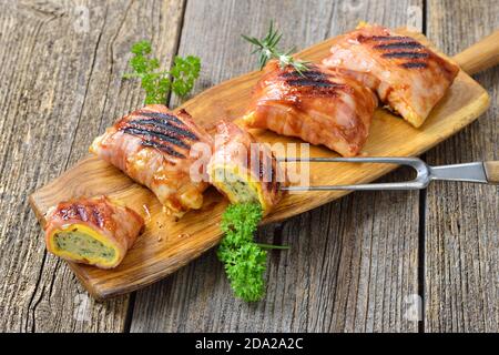 Gegrillte schwäbische Fleischravioli, sogenannte Maultaschen, eingewickelt in Käse und Speck, überzogen mit einer würzigen Grillsoße Stockfoto