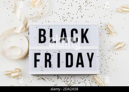 Schwarzer freitag Verkauf Text auf weißem Leuchtkasten, goldene Sterne und Weihnachtsband um auf weißem Hintergrund. thanksgiving Promotion Werbung Stockfoto