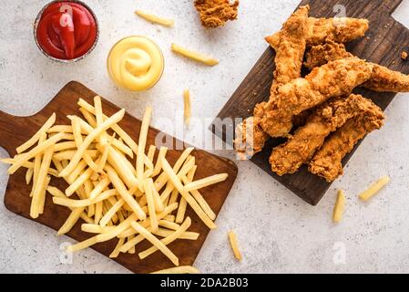 Fisch und Pommes. Frittiertes Fischfilet und mit pommes auf weißem Hintergrund mit Saucen. Traditionelles britisches Street Food. Stockfoto