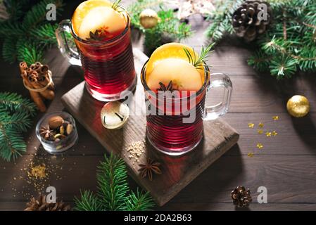 Weihnachtlicher Glühwein mit Gewürzen und Orangen auf rustikalem Holztisch. Traditionelles Heißgetränk für Weihnachten und Winterferien. Stockfoto