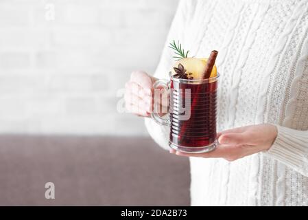 Frau hält Tasse heißen Glühwein, kopieren Raum. Weibliche Hände mit Tasse saisonalen Winter heißen Getränk. Hausgemachtes Obst Weihnachtsgetränk, würzig Glührot Stockfoto