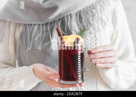 Frau hält Tasse heißen Glühwein. Weibliche Hände mit Tasse saisonalen Winter heißen Getränk. Hausgemachtes Obst Weihnachtsgetränk, würziger Glühwein. Stockfoto