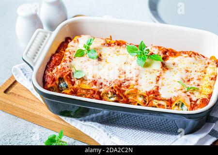 Traditionelle Ricotta und Spinat Cannelloni in Keramikschale. Italienisches Speisekonzept. Stockfoto