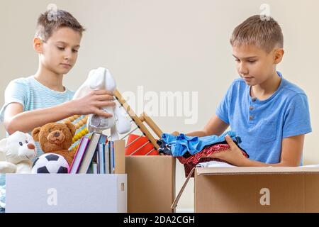 Kinder Freiwillige Sortieren Spielzeug, Kleidung, Bücher, Spenden Waren in Spenden Wohltätigkeitskisten im Haus Stockfoto