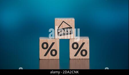 Konzept von Verkauf und Rabatt mit Symbolen auf Holzwürfel Stockfoto