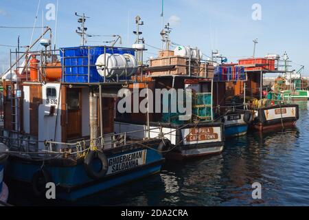 Fischerboote oder Schiffe in einer Reihe oder Reihe in Kalk Bay Hafen, Kapstadt, Südafrika Konzept kommerzielle Fischerei in Afrika Stockfoto