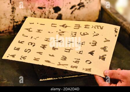 Kyrillisch gedruckt nach der alten Methode der Typografie. Hand des Mannes, der ein Blatt mit dem russischen Alphabet hält. Stockfoto