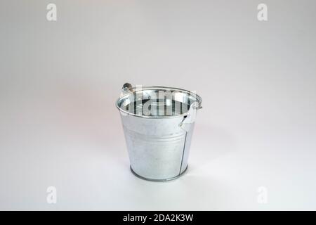 Metall Silber Eimer mit klarem Wasser auf einem weißen gefüllt Hintergrund Stockfoto
