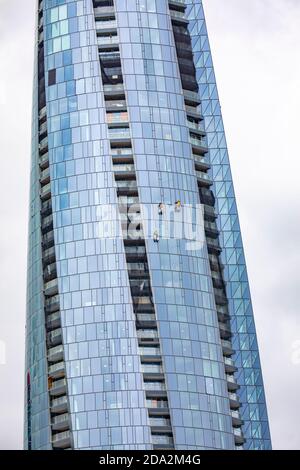 Arbeiter in der Höhe, die die Außenfassade des Wolkenkratzers reinigen Crown Casino in Barangaroo in Sydney, Australien Stockfoto