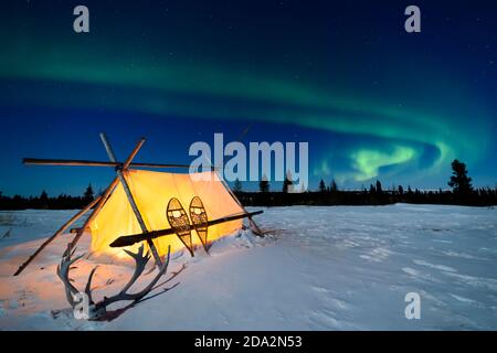 Trappers Zelt, Schneeschuhe und Geweihe unter Nachthimmel mit Aurora Borealis, Nordlichter, Wapusk National Park, Manitoba, Kanada Stockfoto