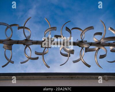 Ein Abschnitt einer rotierenden Wand oben Anti-Climb-Sicherheitsbarriere, gegen einen blauen Himmel an einem sonnigen Tag genommen. Stockfoto