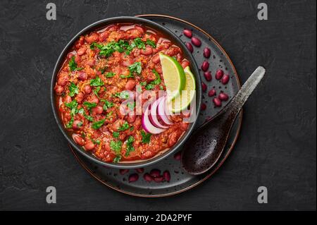 Rajma Masala Curry in schwarzer Schale auf dunkler Schieferplatte. Red Niere Bean Dal ist indische Küche vegetarisches Gericht. Asiatische Küche, Essen. Draufsicht Stockfoto