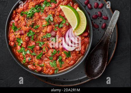 Rajma Masala Curry in schwarzer Schale auf dunkler Schieferplatte. Red Niere Bean Dal ist indische Küche vegetarisches Gericht. Asiatische Küche, Essen. Draufsicht Stockfoto