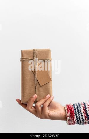 Frau Hand Holding Weihnachtsgeschenk in weißem Hintergrund Stockfoto