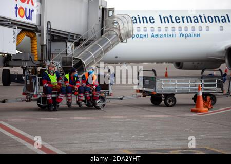 Ukraine, Kiew - 8. Juli 2020: Maskierte Menschen. Der Mann arbeitet während der Quarantäne. Flughafen im Freien. Arbeiter in medizinischen Masken ohne Arbeit. Männer in Uniform Stockfoto
