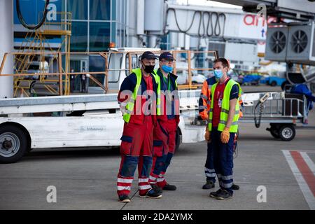 Ukraine, Kiew - 8. Juli 2020: Maskierte Menschen. Der Mann arbeitet während der Quarantäne. Flughafen im Freien. Arbeiter in medizinischen Masken ohne Arbeit. Männer in Uniform Stockfoto