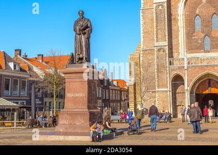 Delft, Niederlande - 8. April 2016: Statue von Hugo Grotius, traditionellen holländischen Häusern, Menschen auf dem Innenstadtplatz des beliebten holländischen Reiseziels Stockfoto