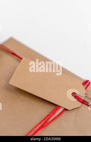 Weihnachtsgeschenk in Recyclingpapier mit roter Schnur und verpackt Ein Etikett Stockfoto