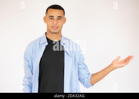 freundlichen jungen Mann zeigt auf seiner Seite und schaut in die Kamera. isoliert auf weißem Hintergrund Stockfoto