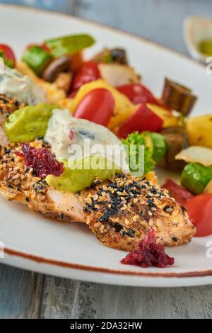 Gegrilltes Hähnchen mit Sesam neben gegrilltem Gemüse auf Holz Tabelle Stockfoto