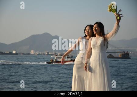 Zwei glückliche Bräute, die im Sai Wan Frachtpier fotografieren (Auch Instagram Pier genannt) in Hongkong Stockfoto