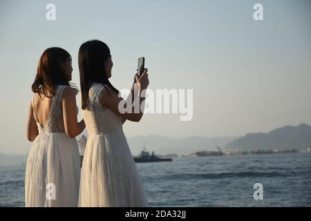 Zwei glückliche Bräute, die im Sai Wan Frachtpier fotografieren (Auch Instagram Pier genannt) in Hongkong Stockfoto