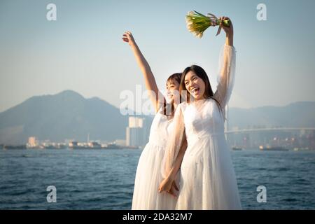 Zwei glückliche Bräute, die im Sai Wan Frachtpier fotografieren (Auch Instagram Pier genannt) in Hongkong Stockfoto