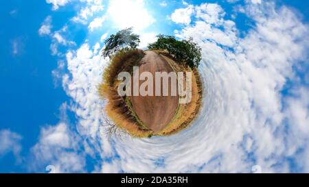 Kleiner Planet mit Bäumen, weißen Wolken und weichen blauen Himmel. Green 360 winzigen Planeten von grünem Gras Ökologie Konzept. Stockfoto
