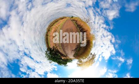 Kleiner Planet mit Bäumen, weißen Wolken und weichen blauen Himmel. Green 360 winzigen Planeten von grünem Gras Ökologie Konzept. Stockfoto