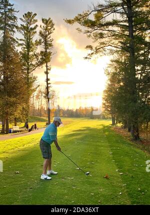 Ein eineinziger Golfspieler, der sich vorbereitet, seinen Ball auf einem zu schlagen Schöner kühler Herbsttag in Kanada Stockfoto