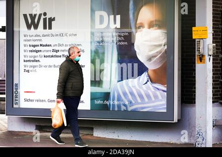 Dortmund, 9. November 2020: Deutsche Bahn die DB Deutsche Bahn AG macht mit großen Plakaten auf das Tragen von Mund- und Nasenschutz in ihren Zügen aufmerksam. Großes Plakat auf einer Plattform am Dortmunder Hauptbahnhof. --- Dortmund, Deutschland, 9.11.2020: Mit großen Plakaten macht die DB Deutsche Bahn AG auf das Tragen von Mund-Nasenschutz in ihren Zügen aufmerksam. Großplakat auf einem Bahnsteig des Dortmunder Hauptbahnhofs. Stockfoto