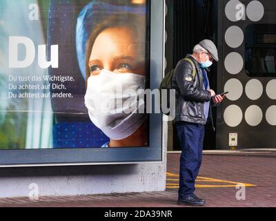 Dortmund, 9. November 2020: Deutsche Bahn die DB Deutsche Bahn AG macht mit großen Plakaten auf das Tragen von Mund- und Nasenschutz in ihren Zügen aufmerksam. Großes Plakat auf einer Plattform am Dortmunder Hauptbahnhof. --- Dortmund, Deutschland, 9.11.2020: Mit großen Plakaten macht die DB Deutsche Bahn AG auf das Tragen von Mund-Nasenschutz in ihren Zügen aufmerksam. Großplakat auf einem Bahnsteig des Dortmunder Hauptbahnhofs. Stockfoto