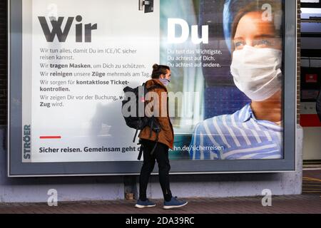 Dortmund, 9. November 2020: Deutsche Bahn die DB Deutsche Bahn AG macht mit großen Plakaten auf das Tragen von Mund- und Nasenschutz in ihren Zügen aufmerksam. Großes Plakat auf einer Plattform am Dortmunder Hauptbahnhof. --- Dortmund, Deutschland, 9.11.2020: Mit großen Plakaten macht die DB Deutsche Bahn AG auf das Tragen von Mund-Nasenschutz in ihren Zügen aufmerksam. Großplakat auf einem Bahnsteig des Dortmunder Hauptbahnhofs. Stockfoto