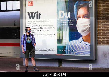 Dortmund, 9. November 2020: Deutsche Bahn die DB Deutsche Bahn AG macht mit großen Plakaten auf das Tragen von Mund- und Nasenschutz in ihren Zügen aufmerksam. Großes Plakat auf einer Plattform am Dortmunder Hauptbahnhof. --- Dortmund, Deutschland, 9.11.2020: Mit großen Plakaten macht die DB Deutsche Bahn AG auf das Tragen von Mund-Nasenschutz in ihren Zügen aufmerksam. Großplakat auf einem Bahnsteig des Dortmunder Hauptbahnhofs. Stockfoto