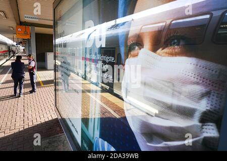 Dortmund, 9. November 2020: Deutsche Bahn die DB Deutsche Bahn AG macht mit großen Plakaten auf das Tragen von Mund- und Nasenschutz in ihren Zügen aufmerksam. Großes Plakat auf einer Plattform am Dortmunder Hauptbahnhof. --- Dortmund, Deutschland, 9.11.2020: Mit großen Plakaten macht die DB Deutsche Bahn AG auf das Tragen von Mund-Nasenschutz in ihren Zügen aufmerksam. Großplakat auf einem Bahnsteig des Dortmunder Hauptbahnhofs. Stockfoto