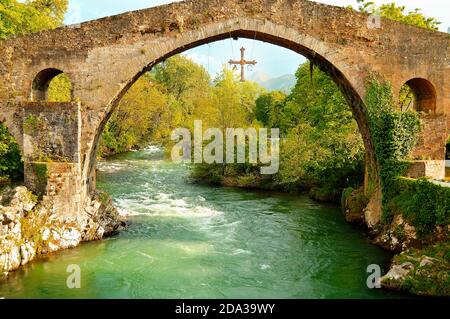 Römische Brücke mit Siegeskreuz auf dem Sella Fluss, Cangas de Onis, Asturien (Spanien). Stockfoto