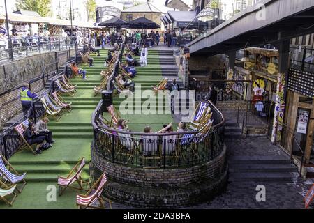 LONDON, VEREINIGTES KÖNIGREICH - 14. Sep 2017: Der zentrale Sitzbereich mit Liegestühlen im Stables Market, Camden. Ein beliebter Ort zum Mittagessen. Stockfoto