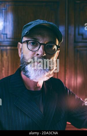 Nahaufnahme der Kopfaufnahme einer männlichen Figur mittleren Alters, die eine Brille trägt Blick auf die Kamera Stockfoto