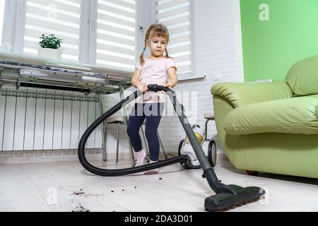 Kind macht die Reinigung mit einem Staubsauger Stockfoto