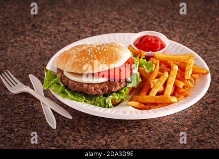 Hamburger im amerikanischen Stil auf einem Sesambrötchen mit Französisch Pommes Frites und Ketchup auf einer Granitoberfläche Stockfoto