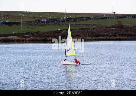 Ein Segelschiff der Topaz-Klasse auf dem kleinen Stausee im Binnenland des Huddersfield Sailing Club in der Nähe von Holmfirth, West Yorkshire Stockfoto