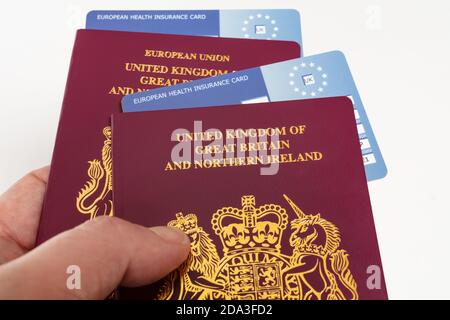 Hand halten Großbritannien britische Pässe und EHIC Europäische Union Krankenversicherungskarten, Stockfoto