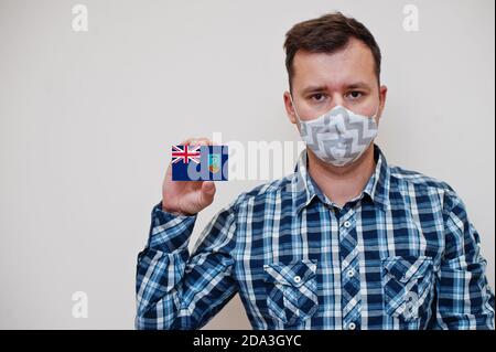 Mann im karierten Hemd zeigen Montserrat Flagge Karte in der Hand, tragen Schutzmaske isoliert auf weißem Hintergrund. Amerikanische Länder Coronavirus Konzept. Stockfoto