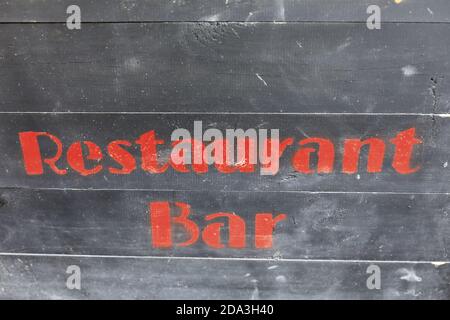 Schild mit Restaurant und Bar an der Holzwand Stockfoto