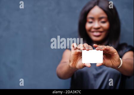 Afrikanische Frau hält leere Karte in den Händen. Stockfoto